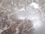 a glass table with a marble top and a metal base