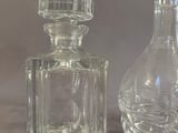 a glass bottle and a glass decanter sitting on a table