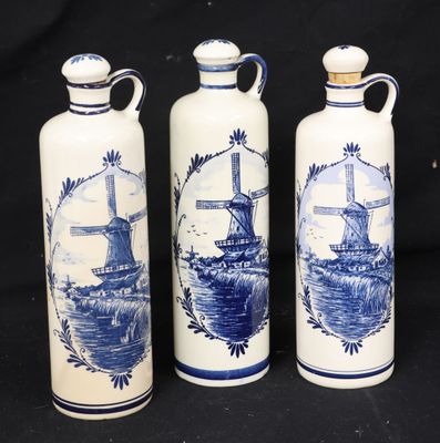 three blue and white vases with windmills on them on a black background