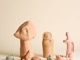 plusieurs figurines en argile de formes et de tailles variées, posées sur une surface blanche