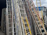 a pile of ladders that are outside of a building