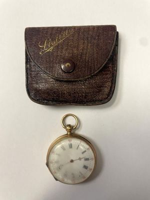 une vieille montre de poche, avec un étui en cuir à côté