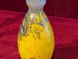a yellow vase sitting on a red cloth on a table