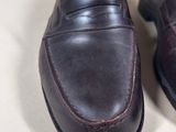 pair of men ' s brown leather shoes on a white surface