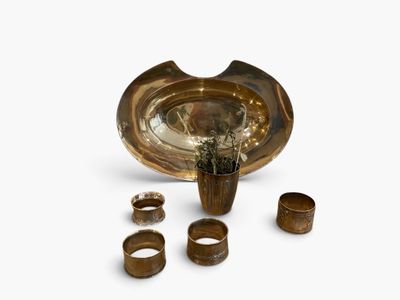several pieces of wood are arranged in a bowl and on a white surface