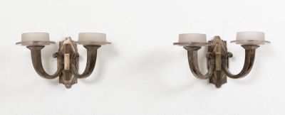une paire d'appliques murales, chacune ornée de bougies, sur un mur blanc
