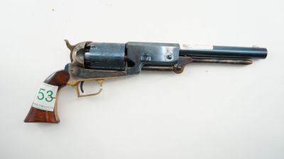 an old revolver with a tag on it sitting on a table