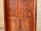 a wooden cabinet with two doors on the top of it