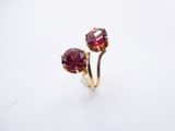 a close up of a pair of red garnets on a white surface