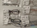 several pairs of eyeglasses are in plastic bags on a table