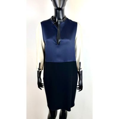 un mannequin portant une robe bleue et blanche avec un nœud noir