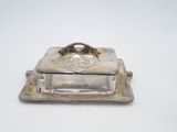 an antique silver plate with a glass lid on a white surface