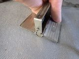 a person holding a metal stapler in their hand