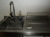 a stainless steel sink with a metal rack and a faucet