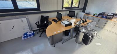 a desk with two computers and a phone on it
