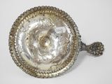 an antique silver plate with a decorative design on it