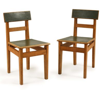 une paire de chaises en bois avec des assises en cuir noir, sur fond blanc