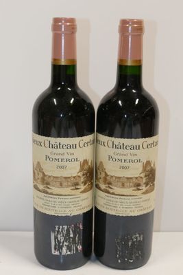 deux bouteilles de vin posées sur une table l'une à côté de l'autre