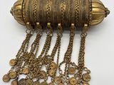 un gros plan d'un collier posé sur une surface blanche, avec des chaînes