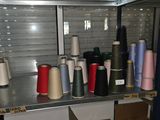 many spools of thread on a shelf in a room
