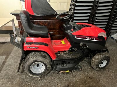 a red riding lawn mower parked in a garage