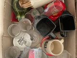 une boîte en carton remplie de verres vides et d'autres objets