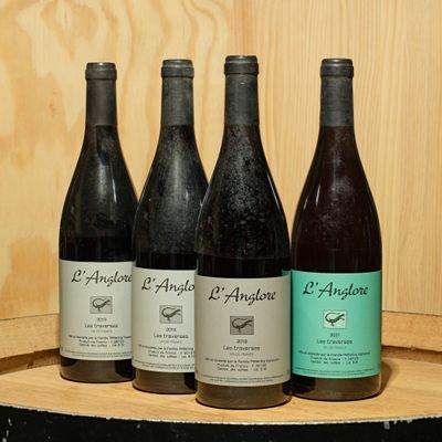 several bottles of wine are lined up on a wooden shelf