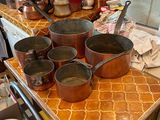 des casseroles et des poêles posées sur une table dans une cuisine dotée d'une fenêtre