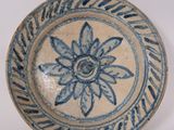 a blue and white plate with a flower on it