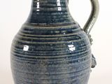 a blue vase that is sitting on a white surface
