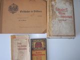 several old books are sitting on a table next to a red box