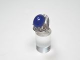 bague sertie d'une pierre bleue et de diamants sur un fond blanc