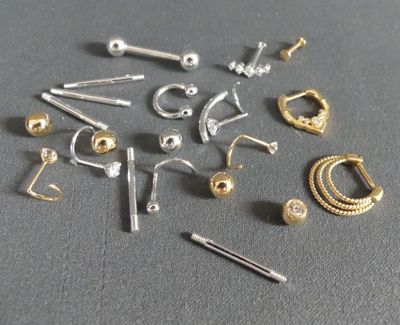 a lot of different types of ear piercings on a table