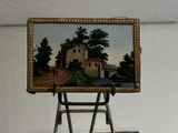 a miniature easel with a painting on it on a table