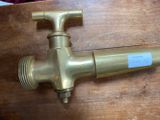 a brass faucet that is on a wooden table