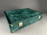 an old green suitcase sitting on top of a white table