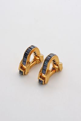 une paire de boucles d'oreilles en or et saphir bleu sur fond blanc