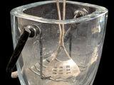 un bol en verre contenant une cuillère, sur fond noir