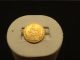a gold coin sitting on top of a piece of paper