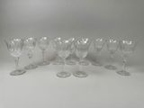 six verres à vin sont alignés sur une surface blanche