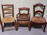 trois chaises en bois placées les unes à côté des autres devant un mur de briques blanches
