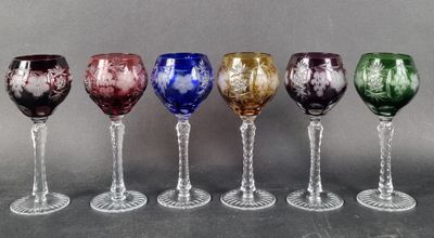several different colored wine glasses are lined up in a row