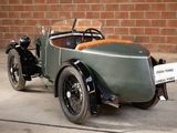 a vintage car that is parked in front of a brick wall