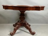 une vieille table en bois dont le plateau est sculpté sur fond blanc