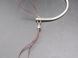 un gros plan d'un bracelet auquel sont attachés deux fils