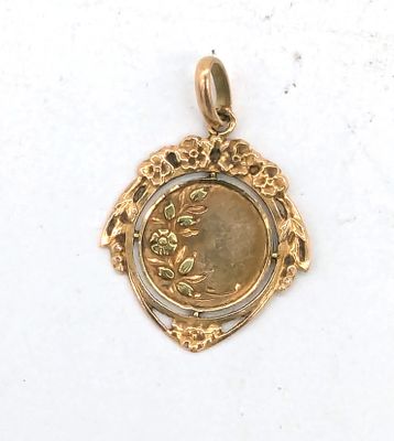 une image représentant un pendentif en or avec une pièce au centre