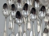 a lot of silver spoons and spoons on the table