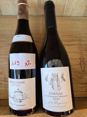 deux bouteilles de vin posées sur une étagère l'une à côté de l'autre