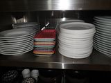 a lot of plates that are stacked on a shelf