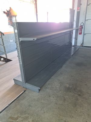une photo d'un garage avec une étagère métallique et des tiroirs